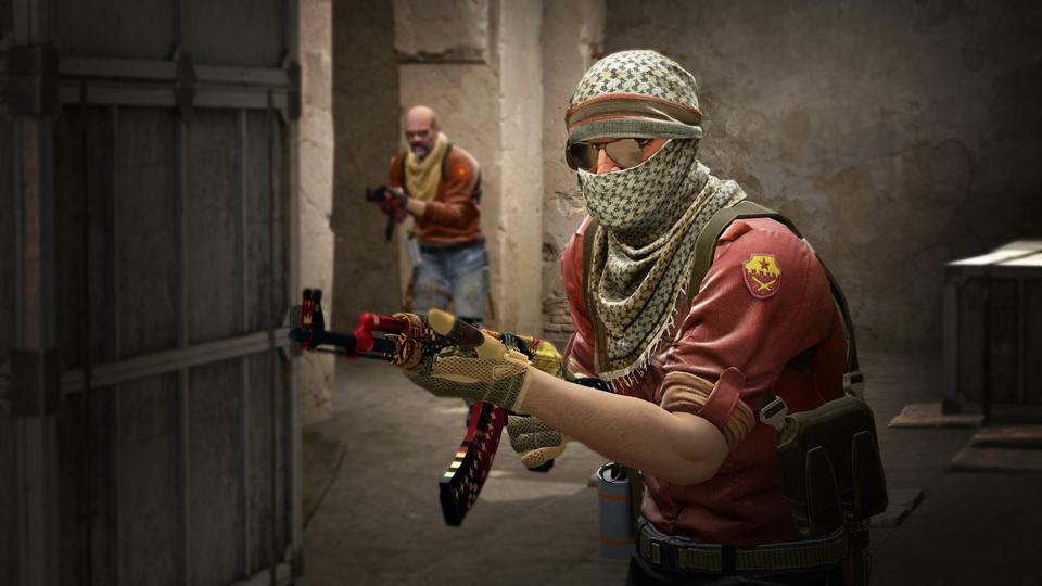 Gameplay scene from Counter-Strike 2 showing armed players inside a dimly lit corridor